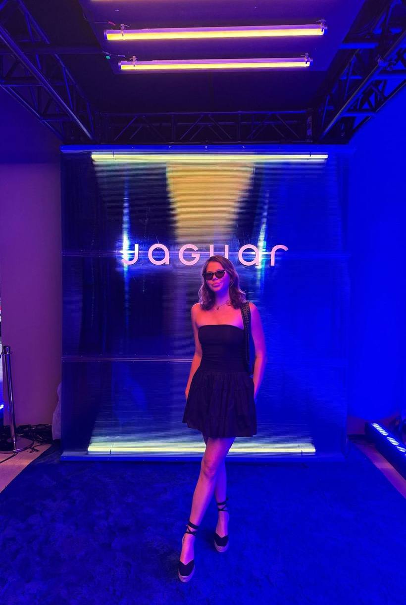 Black strapless dress at a brand activation under blue light