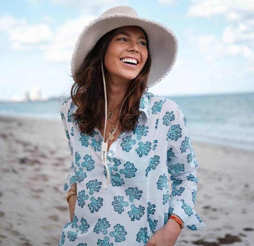 Laughing on the beach in a sun hat and printed tunic