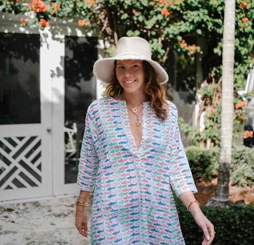 Walking toward camera in a printed kaftan and sun hat