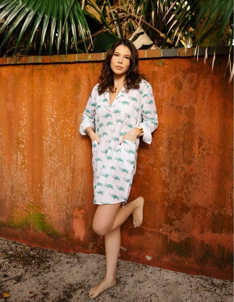 Printed shirt dress against a rust wall
